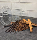 Clear glass mug with vanilla beans, coffee beans, and cinnamon sticks in a simmer pot